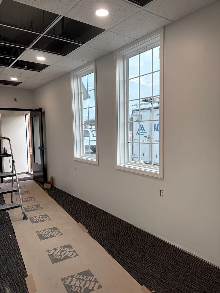 Commercial office interior with gridded windows looking outside at a parked Acme service truck